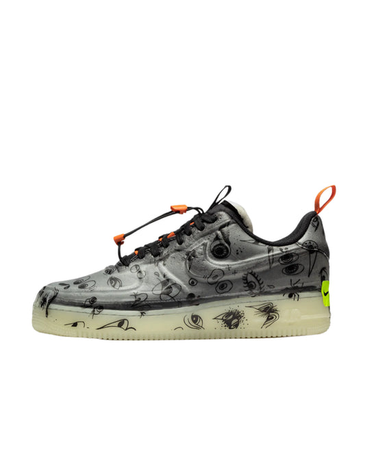 Gray sneaker with black designs and orange accents on a white background